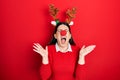 Young hispanic woman wearing deer christmas hat and red nose celebrating mad and crazy for success with arms raised and closed Royalty Free Stock Photo