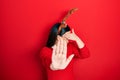 Young hispanic woman wearing deer christmas hat and red nose covering eyes with hands and doing stop gesture with sad and fear Royalty Free Stock Photo