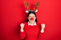 Young hispanic woman wearing deer christmas hat and red nose excited for success with arms raised and eyes closed celebrating Royalty Free Stock Photo