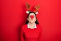 Young hispanic woman wearing deer christmas hat and red nose looking at the camera blowing a kiss on air being lovely and sexy Royalty Free Stock Photo