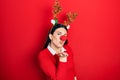 Young hispanic woman wearing deer christmas hat and red nose looking at the camera blowing a kiss with hand on air being lovely Royalty Free Stock Photo