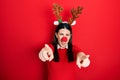 Young hispanic woman wearing deer christmas hat and red nose pointing to you and the camera with fingers, smiling positive and Royalty Free Stock Photo