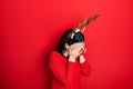 Young hispanic woman wearing deer christmas hat and red nose with sad expression covering face with hands while crying Royalty Free Stock Photo