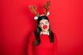 Young hispanic woman wearing deer christmas hat and red nose smiling looking to the side and staring away thinking Royalty Free Stock Photo