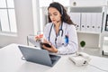 Young hispanic woman wearing doctor uniform having teleconsultation at clinic Royalty Free Stock Photo