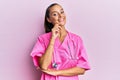 Young hispanic woman wearing doctor uniform and stethoscope looking confident at the camera with smile with crossed arms and hand Royalty Free Stock Photo