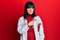 Young hispanic woman wearing doctor uniform and stethoscope pointing aside worried and nervous with forefinger, concerned and Royalty Free Stock Photo