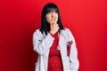 Young hispanic woman wearing doctor uniform and stethoscope thinking worried about a question, concerned and nervous with hand on Royalty Free Stock Photo