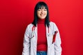 Young hispanic woman wearing doctor uniform and stethoscope winking looking at the camera with sexy expression, cheerful and happy Royalty Free Stock Photo