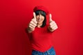 Young hispanic woman wearing french look with beret approving doing positive gesture with hand, thumbs up smiling and happy for Royalty Free Stock Photo