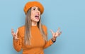 Young hispanic woman wearing french look with beret crazy and mad shouting and yelling with aggressive expression and arms raised Royalty Free Stock Photo