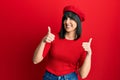 Young hispanic woman wearing french look with beret success sign doing positive gesture with hand, thumbs up smiling and happy Royalty Free Stock Photo