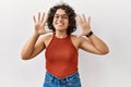 Young hispanic woman wearing glasses standing over isolated background showing and pointing up with fingers number ten while Royalty Free Stock Photo