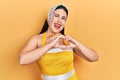 Young hispanic woman wearing pin up style smiling in love doing heart symbol shape with hands Royalty Free Stock Photo