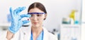 Young hispanic woman wearing scientist uniform holding pill at laboratory Royalty Free Stock Photo