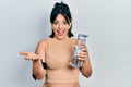 Young hispanic woman wearing sportswear drinking bottle of water celebrating achievement with happy smile and winner expression Royalty Free Stock Photo