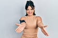 Young hispanic woman wearing sportswear looking at the camera smiling with open arms for hug Royalty Free Stock Photo