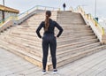 Young hispanic woman wearing sportswear standing on back view looking stairs at street Royalty Free Stock Photo