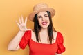 Young hispanic woman wearing summer hat showing and pointing up with fingers number five while smiling confident and happy Royalty Free Stock Photo