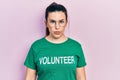 Young hispanic woman wearing volunteer t shirt relaxed with serious expression on face
