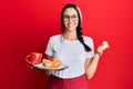 Young hispanic woman wearing waitress apron holding tray with breakfast screaming proud, celebrating victory and success very Royalty Free Stock Photo