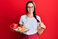 Young hispanic woman wearing waitress apron holding tray with breakfast smiling happy pointing with hand and finger Royalty Free Stock Photo