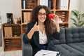 Young hispanic woman working on couple therapy at consultation office smiling happy and positive, thumb up doing excellent and Royalty Free Stock Photo