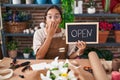 Young hispanic woman working at florist holding open sign covering mouth with hand, shocked and afraid for mistake Royalty Free Stock Photo