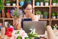 Young hispanic woman working at florist shop doing video call bored yawning tired covering mouth with hand Royalty Free Stock Photo