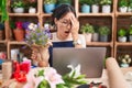 Young hispanic woman working at florist shop doing video call yawning tired covering half face, eye and mouth with hand Royalty Free Stock Photo