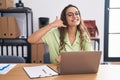 Young hispanic woman working at the office wearing glasses smiling doing phone gesture with hand and fingers like talking on the Royalty Free Stock Photo