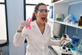 Young hispanic woman working at scientist laboratory looking for breast cancer cure angry and mad screaming frustrated and Royalty Free Stock Photo