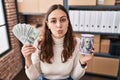 Young hispanic woman working at small business ecommerce holding money and piggy bank looking at the camera blowing a kiss being Royalty Free Stock Photo