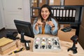 Young hispanic woman working at small business ecommerce selling watches celebrating crazy and amazed for success with open eyes