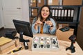 Young hispanic woman working at small business ecommerce selling watches smiling and laughing hard out loud because funny crazy