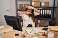 Young hispanic woman working at small business ecommerce smiling cheerful playing peek a boo with hands showing face