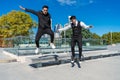 Young Hispanics having fun and jumping from a bench in a public park