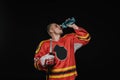 young hockey player drinking water from sports bottle