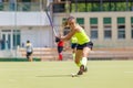 Young hockey player hit ball in field hockey game