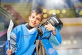 Young hockey player standing next to rink boards Royalty Free Stock Photo