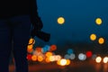 Young holding a camera with abstract blurred light in night time of urban with bokeh background Royalty Free Stock Photo