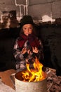 Young homeless boy on the street warming his hands