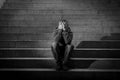 Young homeless man lost in depression sitting on ground street concrete stairs Royalty Free Stock Photo