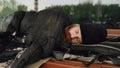 Young Homeless man trying to sleep under jacket on bench at the sidewalk Royalty Free Stock Photo