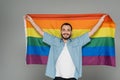 Young homosexual man holding lgbt flag