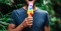 Young homosexual man sexy licking colourful lgbt rainbow symbol ice cream on a gay pride celebration. Lesbian, gay, bisexual, tran