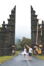 Young honeymoon couple on a big balinese gates background. Bali island, Indonesia.