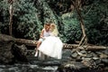 Young honeymoon newleds couple kissing on a mountain river. Bali island.