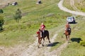 Young horsemen gallop across the Starishora mountain valley, Ukraine.