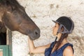 Young horsewoman with its horses in the stable Royalty Free Stock Photo